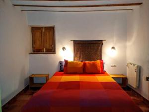 a bedroom with a colorful bed with two orange pillows at Casa del Agua in Cabeza Gorda