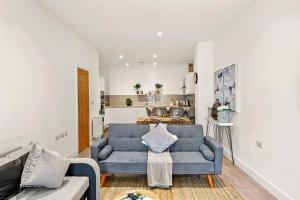 a living room with a blue couch and a kitchen at Stunning Scandi Gem in Bristol - Sleeps 6 in Bristol