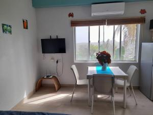 een eetkamer met een tafel en stoelen en een raam bij Tranquility with Stunning View in Morne Jaloux Ridge