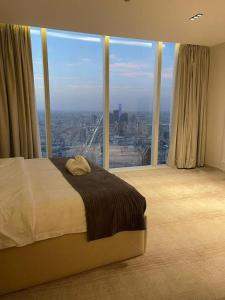 een slaapkamer met een bed en een groot raam bij Raffal Tower Apartment in Riyad