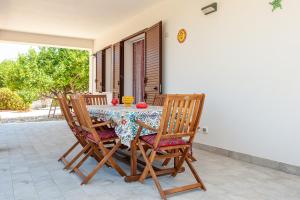 een tafel en stoelen op een patio met een tafel en tenen bij AL BARONE in Scopello