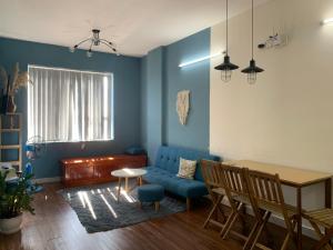 een woonkamer met een blauwe bank en een tafel bij HOMESTAY KHÁCH SẠN NINH THUẬN in Thôn Mỹ Phước