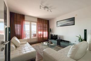 uma sala de estar com um sofá branco e uma mesa em Apartman Cruiser em Zadar