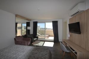 une chambre d'hôtel avec un lit et un salon dans l'établissement Studio Ève Résidence Naturiste Le Jardin D'Eden, au Cap d'Agde