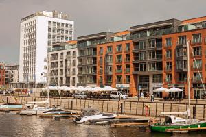 a group of boats docked in a harbor with buildings at Euro Apartments Szafarnia Delux in Gdańsk
