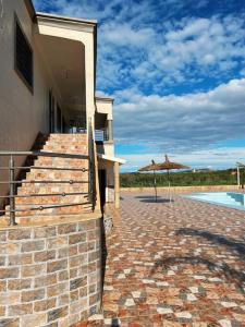 a house with a patio with an umbrella and a pool at Dar Sakina with Private Pool in Oulad Zenati