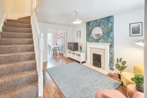 uma sala de estar com uma escada e uma lareira em Host & Stay - Garden Cottage em Durham