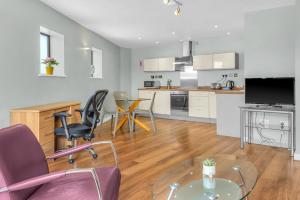 a kitchen and living room with a table and chairs at Roomzzz Leeds Headingley in Leeds