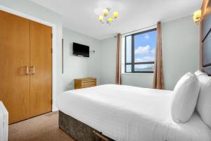 a bedroom with a large white bed and a window at Roomzzz Leeds Headingley in Leeds