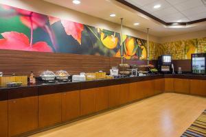 a restaurant with a counter with food on it at Fairfield Inn & Suites Louisville East in Louisville