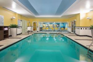 una piscina con acqua blu in una camera d'albergo di Fairfield Inn & Suites Louisville East a Louisville