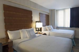 a hotel room with two beds and a window at Fairfield Inn & Suites by Marriott New York Manhattan/Fifth Avenue in New York