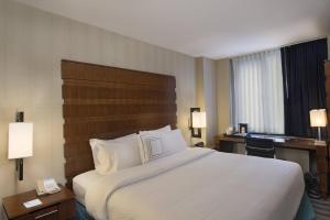 um quarto de hotel com uma cama grande e uma secretária em Fairfield Inn & Suites by Marriott New York Manhattan/Fifth Avenue em Nova York