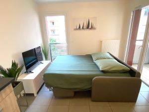 1 dormitorio con 1 cama y TV. en Appartement T2 cosy centre ville, en Thonon-les-Bains