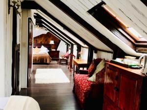 a bedroom with a bed and a red couch in a room at Harfield Guest Villa in Cape Town +31 photos