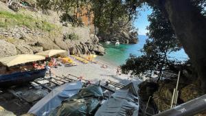 a beach with tents and people in the water at Casa dell'Arco Civico 35 in San Fruttuoso