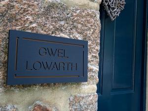 ein Schild an einer Steinmauer mit den Worten: geringe Bandbreite in der Unterkunft Gwel Lowarth Central Penzance - lovely one bedroom apartment. in Penzance