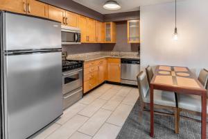 a kitchen with a stainless steel refrigerator and a table at Residence Inn Sacramento Rancho Cordova in Rancho Cordova