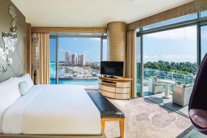 a hotel room with a bed and a large window at W Singapore - Sentosa Cove in Singapore