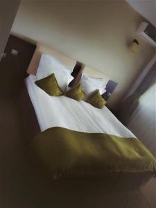 1 dormitorio con 1 cama con almohadas verdes en Forest Retreat&Spa en Oveselu