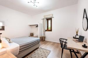a bedroom with a bed and a desk with a laptop at Joel Living Collection - Rustic Villa in Áptera