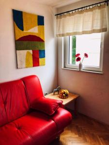Sofá rojo en una habitación con mesa y ventana en M5 en Promajna