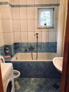 y baño con bañera, aseo y lavamanos. en M5 en Promajna