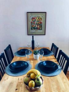 una mesa de madera con platos azules y un bol de fruta en M5 en Promajna