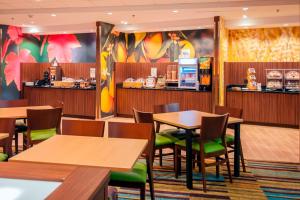 a restaurant with tables and chairs and a counter at Fairfield Inn & Suites by Marriott San Antonio Brooks City Base in San Antonio