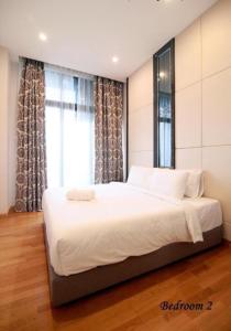 a bedroom with a large white bed with a window at Dorsett Residences Bukit Bintang in Kuala Lumpur