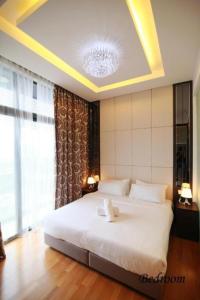 una camera con un letto bianco e una grande finestra di Dorsett Residences Bukit Bintang a Kuala Lumpur