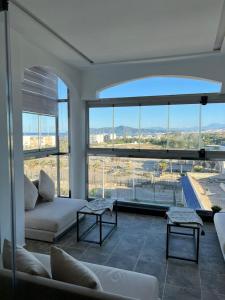 a living room with a couch and a large window at Casa Marina Smir in Marina Smir