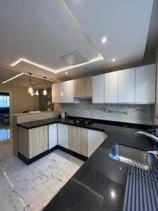 a kitchen with white cabinets and a black counter top at Casa Marina Smir in Marina Smir