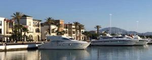 three boats are docked in the water near buildings at Casa Marina Smir in Marina Smir
