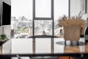 einen Tisch mit Stadtblick aus dem Fenster in der Unterkunft Mega Style Apartments Bella in Melbourne
