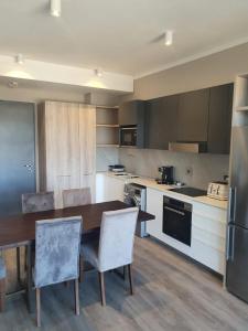 a large kitchen with a wooden table and chairs at Menlyn Maine Trilogy Apartment 509 in Pretoria