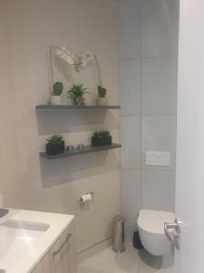 a white bathroom with a toilet and a sink at Menlyn Maine Trilogy Apartment 509 in Pretoria