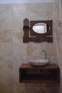 a bathroom with a sink and a mirror on a wall at hotel batukaras kalaras in Batukaras