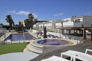 un complexe avec une piscine, des chaises et un bâtiment dans l'établissement Studio Ève Résidence Naturiste Le Jardin D'Eden, au Cap d'Agde