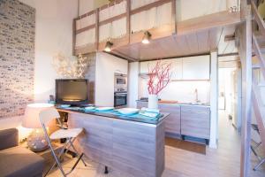 a kitchen with a counter with a tv and a couch at Casa Pace Stintino in Stintino