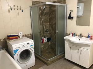 a bathroom with a shower and a washing machine at House of Grace in Reni