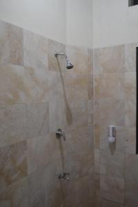 a shower with a shower head in a bathroom at hotel batukaras kalaras in Batukaras