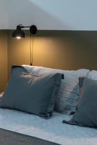 a bed with pillows and a lamp on top of it at Departamento céntrico II con estacionamiento gratis in San Salvador de Jujuy