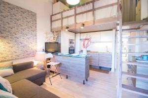 a living room with a couch and a kitchen at Casa Pace Stintino in Stintino +40 photos