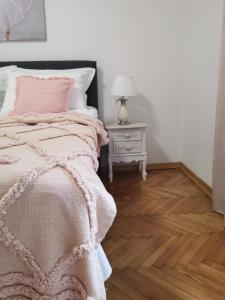1 dormitorio con 1 cama y 1 mesa con lámpara en Kuća JEKA, en Vrnjačka Banja