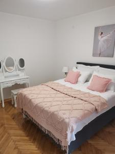 a bedroom with a large bed with pink pillows at Kuća JEKA in Vrnjačka Banja