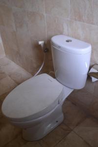 a bathroom with a white toilet in a room at hotel batukaras kalaras in Batukaras