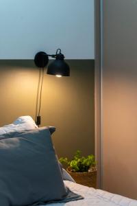 una lámpara junto a una cama con almohada en Departamento céntrico II con estacionamiento gratis en San Salvador de Jujuy