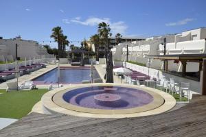 a pool with a fountain in the middle of a building at Studio Ève Résidence Naturiste Le Jardin D'Eden in Cap d'Agde