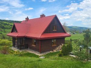 mały dom z czerwonym dachem na polu w obiekcie Willa Wirchnia w mieście Małastów